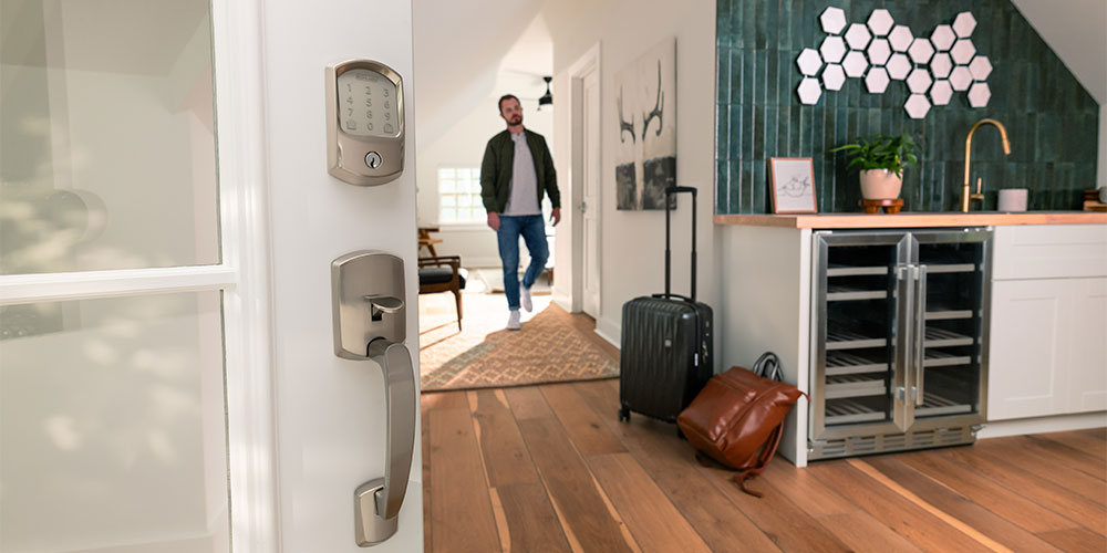 Close up of smart lock on a front door as the home owner with suitcases prepares to leave for vacation.